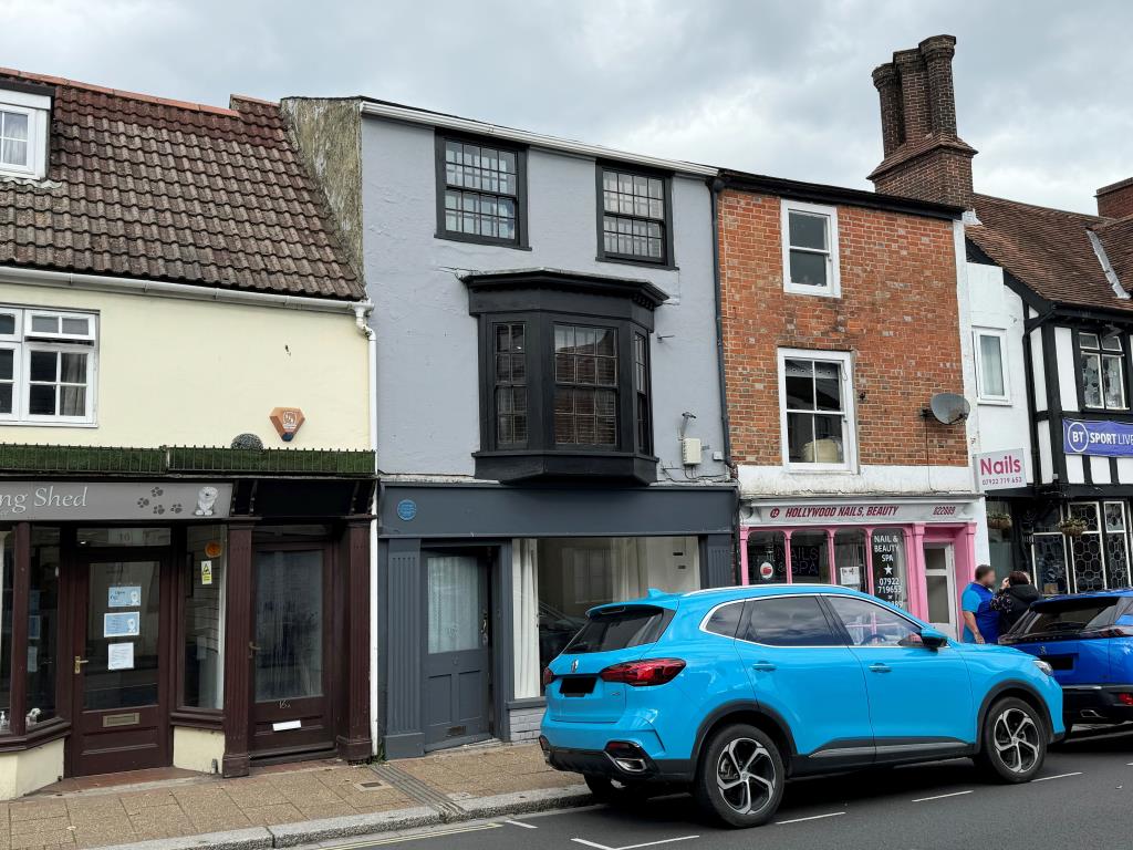 Lot: 69 - SHOP AND TWO-BEDROOM FLAT FOR INVESTMENT OR OWNER OCCUPATION - Terraced building painted grey with commercial unit on ground floor